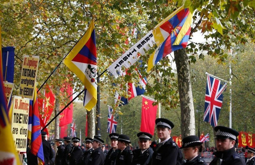 Police officers stand in front of pro-Tibet protesters as they wait on the Mall for China's President Xi Jinping to pass during his ceremonial welcome, in London, Britain, October 20, 2015.  REUTERS/Peter Nicholls