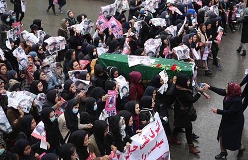 Afghan women carry the coffin of a 9 year-old girl as thousands march in the Afghan capital of Kabul on Wednesday, Nov. 11, 2015 with the coffins of seven ethnic Hazaras who were allegedly killed by the Taliban, calling for a new government that can ensure security in the country.  Farsi posters carried by the protesters call for security ant call on Prsident Ashraf Ghani to resign.(AP Photos/Massoud Hossaini)