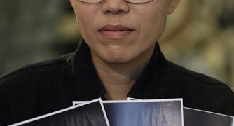 Liu Xia, the wife of Chinese dissident Liu Xiaobo, holds photos of Liu Xiaobo during an interview in Beijing October 3, 2010. Chinese dissident Liu Xiaobo is tipped to win the 2010 Nobel Peace Prize, according to a leading bookmaker, as the Nobel Committee seeks to restore its authority after criticism of the 2009 pick of U.S. President Barack Obama. REUTERS/Petar Kujundzic (CHINA - Tags: POLITICS)