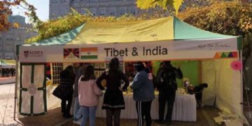 People gather at a booth, which shows a Tibetan and Indian flags placed side by side at the International Students' Festival of Korea University on 14 November 2018.