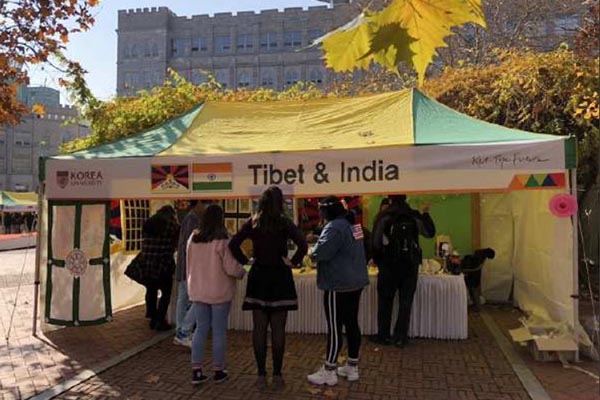 People gather at a booth, which shows a Tibetan and Indian flags placed side by side at the International Students' Festival of Korea University on 14 November 2018.
