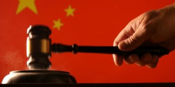 Judge hammer and gavel with Chinese flag background in a court of law that is used for judgement legislation and government juridical systems.