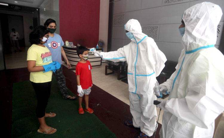 Maharashtra, July 18(ANI): Health workers wearing PPE kit check the temperature, blood oxygen screening of a child for COVID-19 symptoms at a residential building at Adarsh Nagar area of Malad, in Mumbai on Saturday. (ANI Photo)