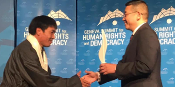 Tibetan filmmaker Dhondup Wangchen receives the prestigious Courage Award from the Chinese dissident and former political prisoner Yang Jianli on Mar 27. (Photo courtesy: Geneva Summit)