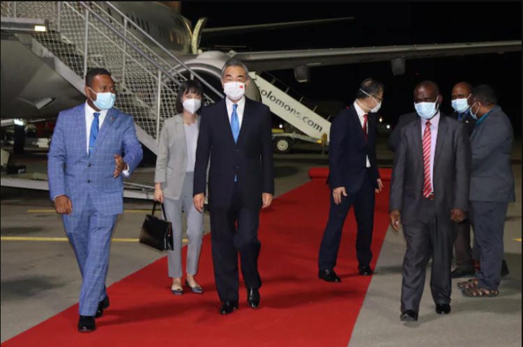 The Solomon Islands' foreign minister, Jeremiah Manele, left, escorts his Chinese counterpart, Wang Yi, center, upon Wang's arrival in Honiara on May 25. (AFP/Getty Images)