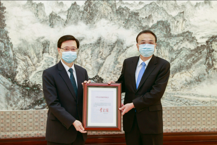 Chinese Premier Li Keqiang (right) presents the certificate of appointment to Hong Kong Chief Executive-elect John Lee. Photo: Handout