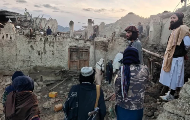 Afghans look at destruction caused by an earthquake in the province of Paktika, eastern Afghanistan [Bakhtar News Agency via AP]