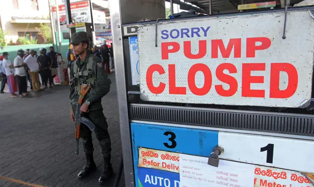 A Sri Lankan security official stands guard outside a fuel station that ran out of petrol in Colombo, Sri Lanka on Monday. Photograph: AFP/Getty Images