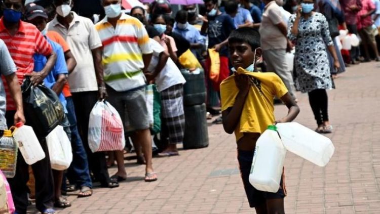 People stand in a queue to buy kerosene oil for home use at a petrol station in Colombo. AFP
