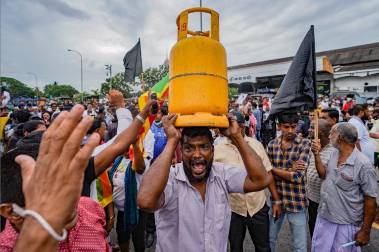 A man lifts a gas tank amid fuel shortages and an ongoing economic crisis as he joins a protest to demand the resignation of Sri Lankan President Gotabaya Rajapaksa in Colombo, Sri Lanka, on June 30. THILINA KALUTHOTAGE/NURPHOTO VIA GETTY IMAGES