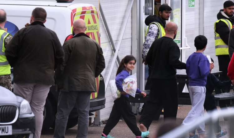 FILE - Migrants are seen inside the Manston short-term holding center near Ramsgate, southeast England, Nov. 3, 2022