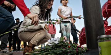 MONTEREY PARK, CA - JANUARY 22: A woman and a little girl places flowers at a memorial where community members gathered for vigil to the people who were killed by a gunman who opened fire at a ballroom dance studio on Sunday, Jan. 22, 2023 in Monterey Park, CA. (Jason Armond / Los Angeles Times via Getty Images)