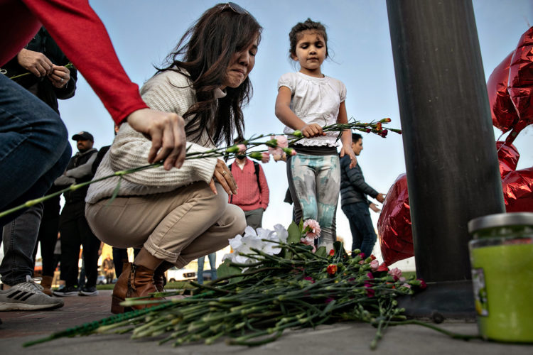 MONTEREY PARK, CA - JANUARY 22: A woman and a little girl places flowers at a memorial where community members gathered for vigil to the people who were killed by a gunman who opened fire at a ballroom dance studio on Sunday, Jan. 22, 2023 in Monterey Park, CA. (Jason Armond / Los Angeles Times via Getty Images)