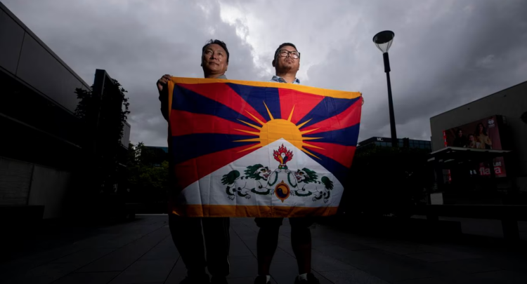 Tibetan community leaders Nyandak Rishul, president of the NZ Tibetan Association, and Wangdue Tsering, past president, with the Tibetan flag. Photo / Dean Purcell