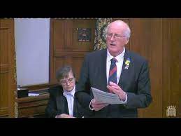 སྐབས་དེར་དབྱིན་ཇིའི་རྒྱལ་ཡོངས་གྲོས་ཚོགས་འཐུས་མིའི་རྒྱལ་སྤྱིའི་ཆོས་དད་རང་དབང་ལྷན་ཚོགས་ཀྱི་ཚོགས་གཙོ་དང་གྲོས་ཚོགས་འཐུས་མི་སྐུ་ཞབས་ཇིམ་ཤན་ནོན་ (Jim Shannon) ལགས་ཀྱིས་བོད་ཀྱི་ཆོས་དད་རང་དབང་གི་གནས་སྟངས་སྐོར་ལ་གསུང་བཤད་གནང་བཞིན་པ། དབྱིན་ཇིའི་གྲོས་ཚོགས་ཀྱི་པར། ༡༤།༡༢།༢༠༢༣