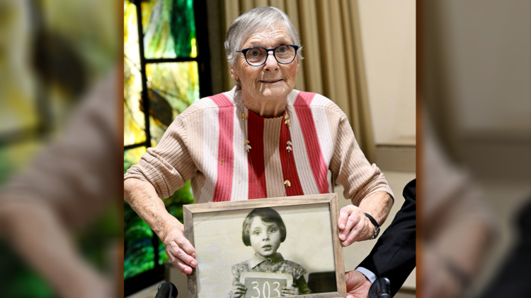  Holocaust and October 7 survivor Mirjam Beit Talmi Szpiro holding a photo of herself as a 3-year-old in Amsterdam, 1939, on the way to Britain