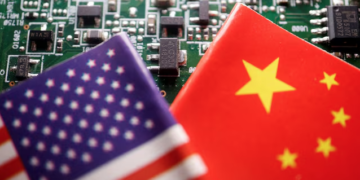 Flags of China and U.S. are displayed on a printed circuit board with semiconductor chips, in this illustration picture taken February 17, 2023. REUTERS/Florence Lo/Illustration/File Photo