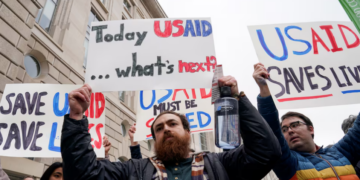 People hold placards outside the USAID building, after billionaire Elon Musk, who is heading U.S. President Donald Trump's drive to shrink the federal government, said work is underway to shut down the U.S. foreign aid agency USAID, in Washington, U.S., February 3, 2025. REUTERS/Kent Nishimura