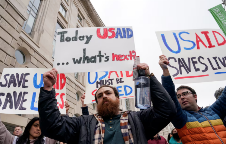 People hold placards outside the USAID building, after billionaire Elon Musk, who is heading U.S. President Donald Trump's drive to shrink the federal government, said work is underway to shut down the U.S. foreign aid agency USAID, in Washington, U.S., February 3, 2025. REUTERS/Kent Nishimura