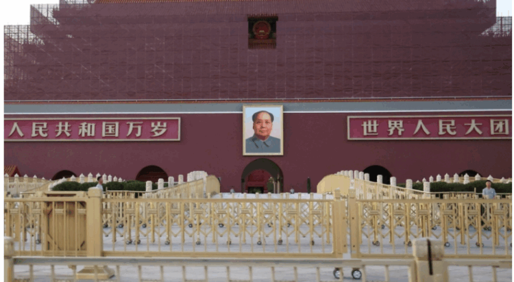 Security personnel keep watch near the portrait of late Chinese Chairman Mao Zedong displayed on the Tiananmen Gate, in Beijing on Tuesday. | REUTERS