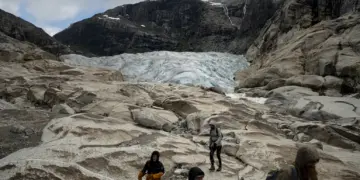 Tourists hike to visit the Nigardsbreen glacier in Jostedal, Norway in August 2022. Bram Janssen/AP