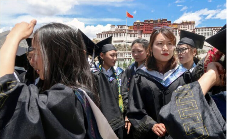 University students wearing graduation gowns take part in a photo-shooting session on the Potala Palace Square during a government-organised media tour to Lhasa, Tibet Autonomous Region, China June 1, 2021. Picture taken June 1, 2021. REUTERS/Martin Pollard/File Photo
