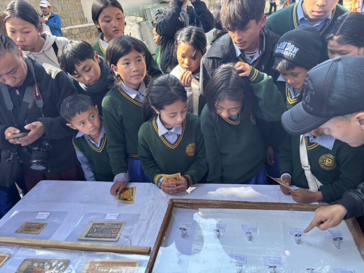 བོད་དངུལ་འགྲེམས་སྟོན་དུ་དྷ་སྟེང་བོད་ཁྱིམ་སློབ་གྲྭའི་སློབ་ཕྲུག་རྣམས་ཀྱིས་ལྟ་སྐོར་བྱེད་བཞིན་པ། ༢༠༢༦།༢།༡༣ དུས་བབ་གསར་ཁང་གི་པར།