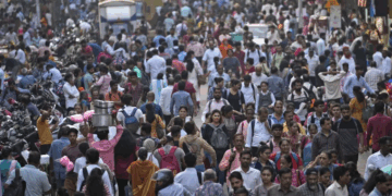 A large crowd walks in a market area outside Dadar station in Mumbai, India, Friday, March 17, 2023. [AP Photo/Rajanish Kakade]