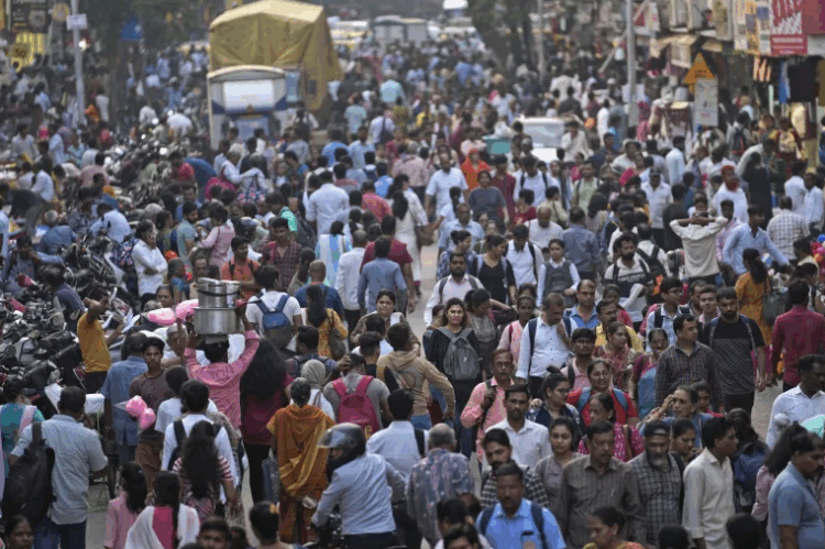 A large crowd walks in a market area outside Dadar station in Mumbai, India, Friday, March 17, 2023. [AP Photo/Rajanish Kakade]