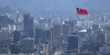 A Taiwan flag is carried by a Chinook helicopter during a rehearsal for the upcoming National Day celebration in Taipei, Photo :REUTERS/Ann Wang/File